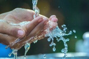 Personne en train de boire de l'eau avec ses mains