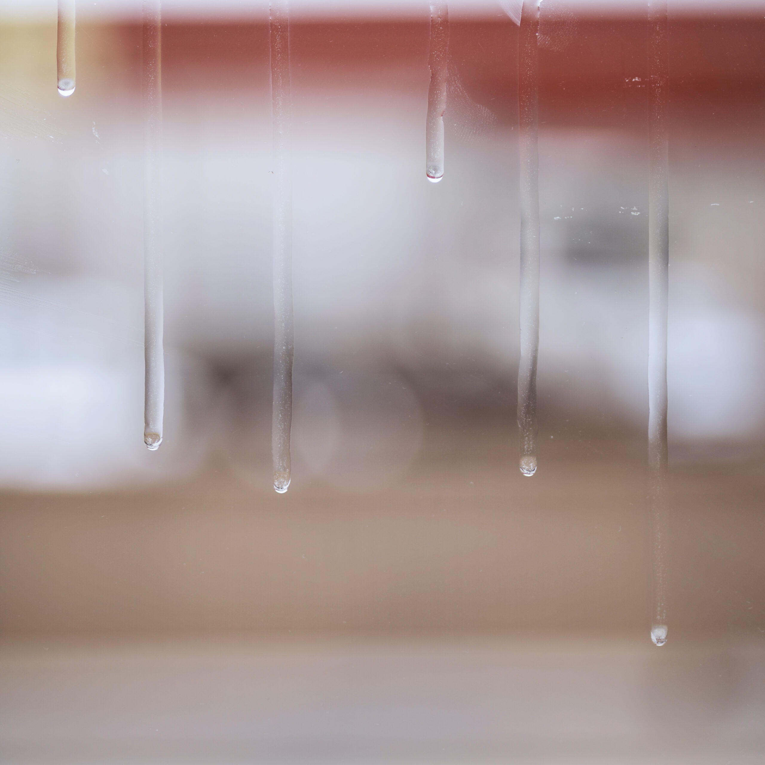 Image de gouttes d'eau ruisselant sur le carreau d'une fenêtre.